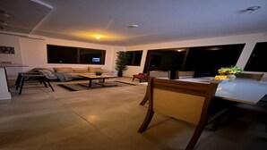 Una sala moderna con sofá, mesa de centro y comedor.