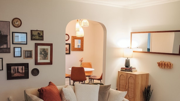 Una sala de estar con un sofá, una mesa de centro y un comedor al fondo.