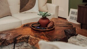 Una sala de estar con un sofá blanco, una mesa de centro de madera y una lámpara.