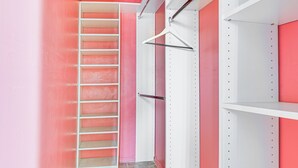 A closet with pink walls, white shelves, and a metal hanger rack. - 8 Mi to Dtwn LA: Apt w/ Shared Patio! (Los Angeles)