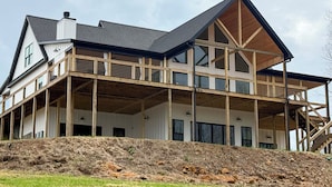 A modern two-story house with a large balcony and a steeply pitched roof. - Spacious Home in Paradise Grove Nolin Lake! (Clarkson)