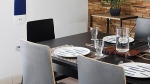 Un comedor moderno con pared de madera, una planta en maceta y una pala de madera.