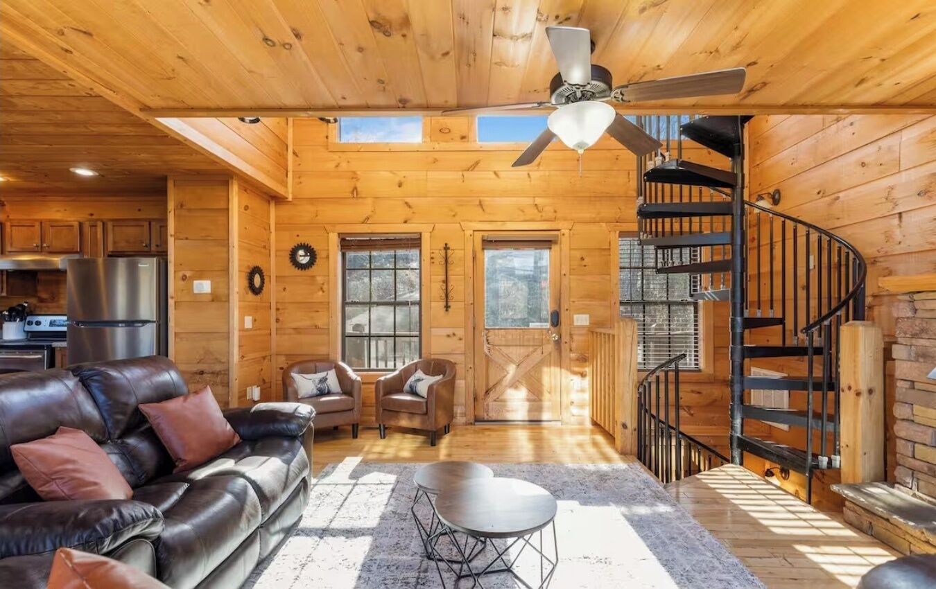 L’intérieur d’une cabane en rondins comprend un salon, un coin repas, une cuisine et un escalier en colimaçon.