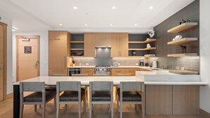 Una cocina moderna con una isla central, armarios de madera y estantes empotrados.