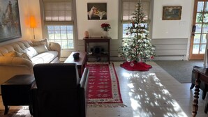 Una sala de estar acogedora con chimenea, un sofá, una mesa de centro y un árbol de Navidad.