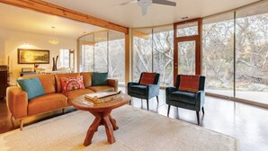 A spacious living room with a large window, a ceiling fan, and a wooden ceiling. - River Spirit- Arquitectural wonder of the Sequoias (Three Rivers)