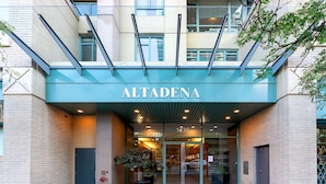 Fasaden på byggnaden i Altadena, med en entré av glas, en krukväxt och en brandpost.