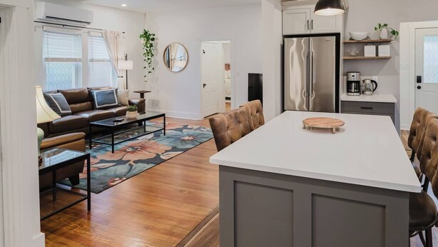 A modern kitchen with a central island, stainless steel appliances, and a dining area with a large table.