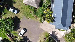 An aerial view of a residential area with a swimming pool, a thatched-roof structure, and a large blue-roofed building. - Tiki Ora Lodge - HURA  (Bora Bora)