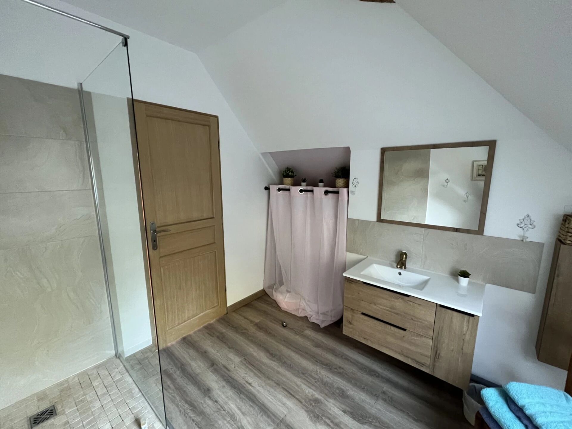 Une salle de bain moderne avec une douche, un lavabo et un miroir.