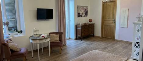 Une chambre confortable avec un grand lit, un bureau avec une chaise, une télévision et une commode.