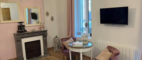 Una sala de estar acogedora con chimenea, televisor y ventana con cortinas.