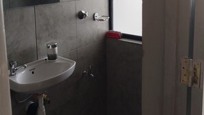 A bathroom with a sink, mirror, and window.