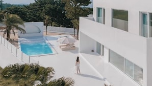 Un bâtiment moderne doté d’une piscine et d’un espace extérieur aménagé pour se détendre.