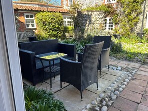 Relax on the patio surrounded by lush greenery and enjoy the serene atmosphere.