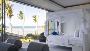 A bedroom with a bed, a canopy, a view of the beach, and a balcony with seating. - Bella Samui Beach Villa (Koh Samui)