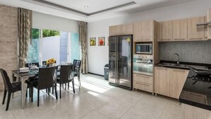 Een moderne keuken met een eethoek, een koelkast, een magnetron en een spoelbak.
