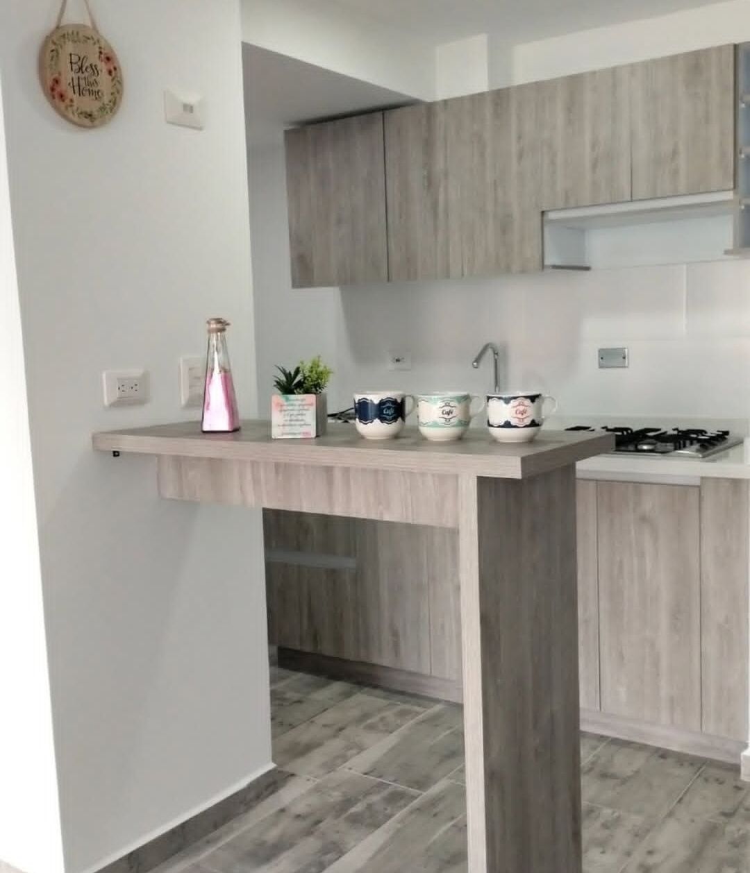 Une cuisine moderne avec des meubles en bois, un plan de travail et une cuisinière encastrée.