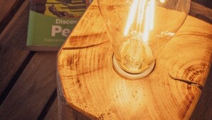 A table with a lit bulb and a book titled "Discover Peru." - Dona Catta Boutique Loft—Just 10 minutes from the station! (Ollantaytambo)