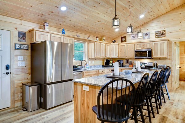 A modern kitchen with wooden cabinetry, stainless steel appliances, and a central island with bar stools. - Amazing mountain views! Book now for Fall! (Murphy)