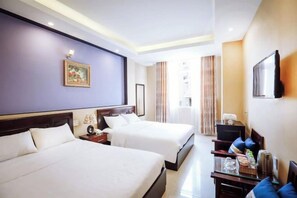 A hotel room with two beds, a desk, a chair, a TV, and a window with curtains. - Empress Dalat Hotel (Dalat)