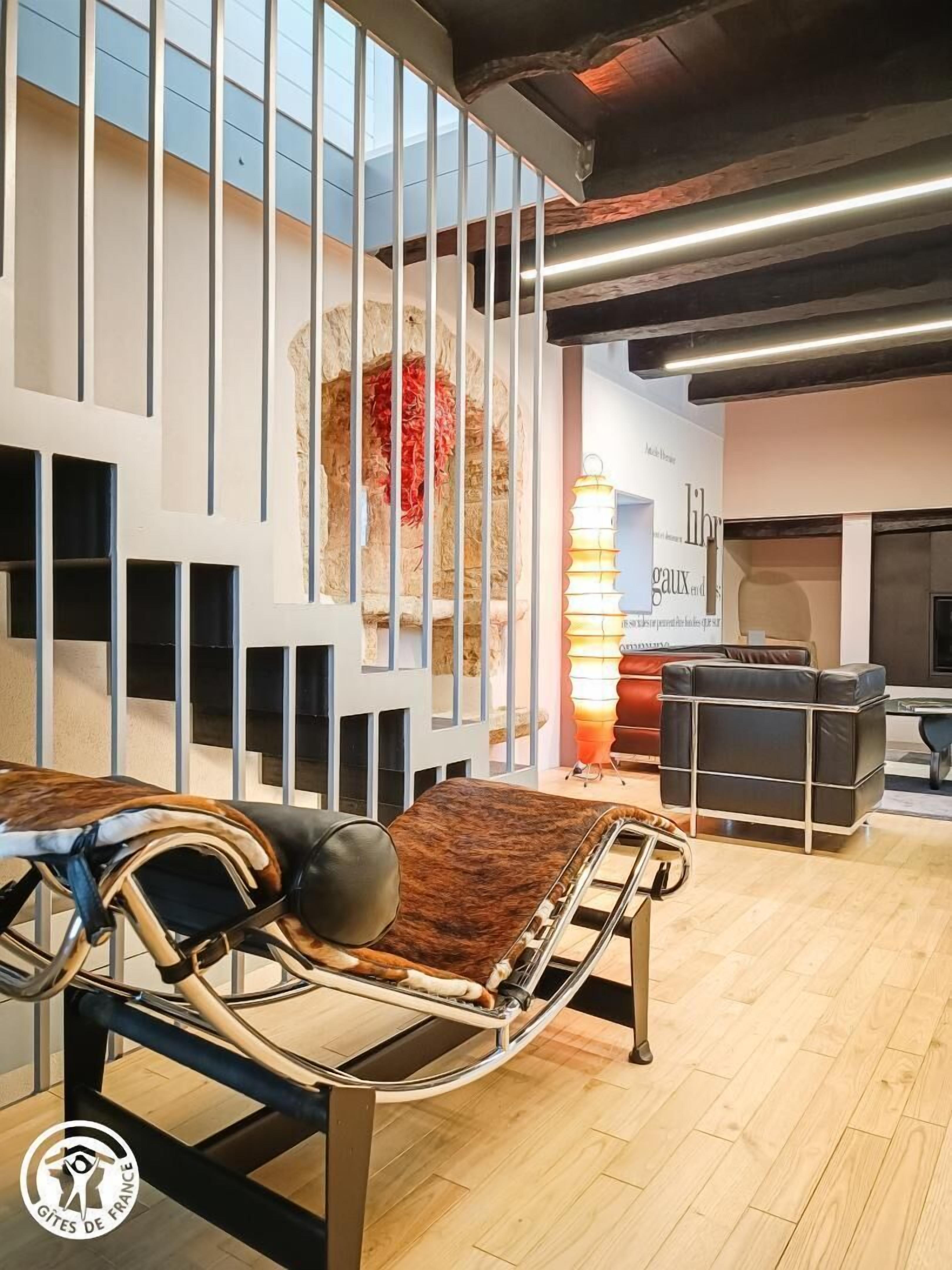 A modern interior with a bed, a sofa, and a decorative wall.