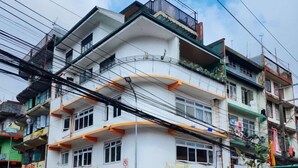 A multi-story building with balconies, a sign for a meat shop, and visible power lines. - RedDoorz near Baguio Night Market (Baguio)