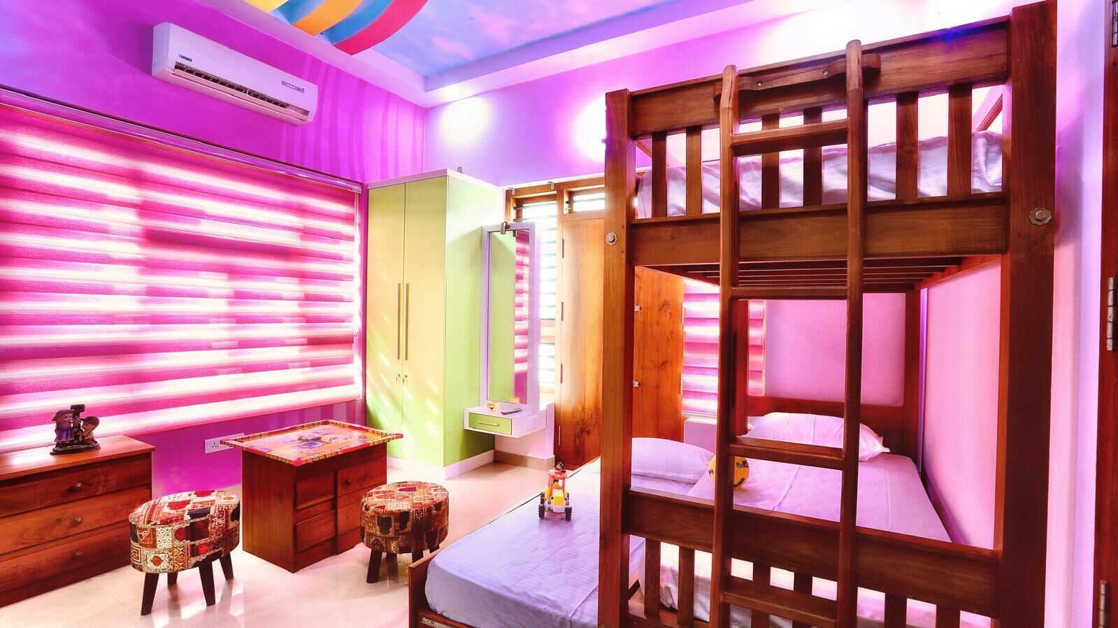 A room with bunk beds, a desk, a chair, and a wardrobe.