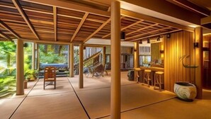 Um interior moderno com teto de madeira, escada e espaço para bar.