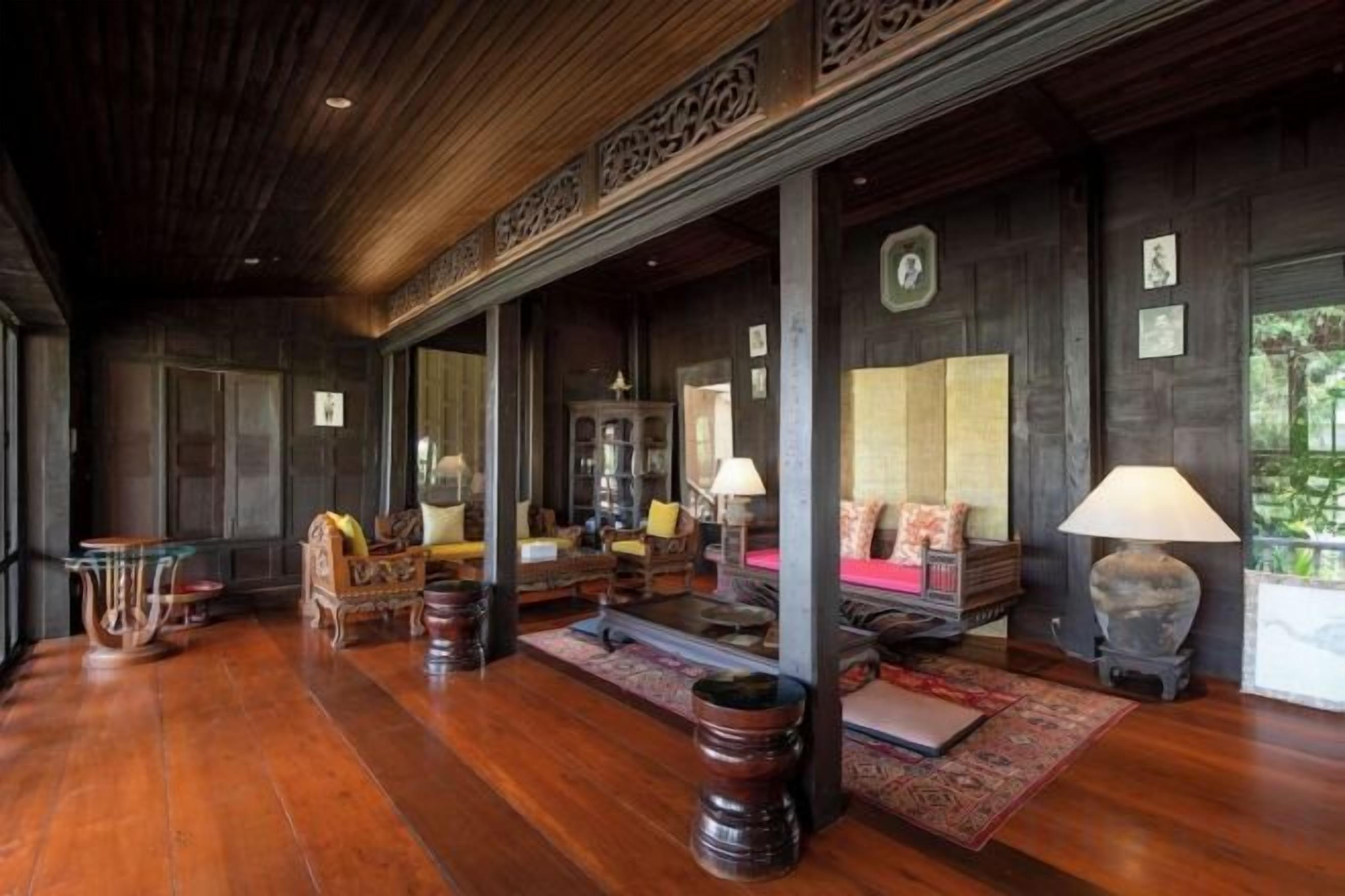 A traditional room with wooden flooring, a sofa set, a table, and a lamp.