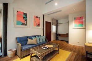 Un salon avec un canapé, une table basse et des œuvres d’art accrochées aux murs.