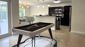 Une cuisine moderne avec un billard, un coin repas et une vue sur l’extérieur.