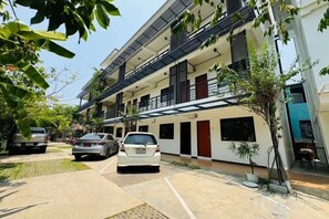 A multi-story residential building with a covered parking area, a small garden, and a balcony. - Saengcanthr (Nakhon Ratchasima)