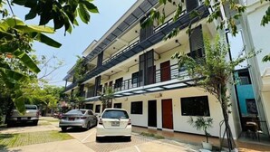 A multi-story residential building with balconies, a driveway, and parked cars. - Saengcanthr (Nakhon Ratchasima)