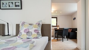 Un dormitorio con cama, escritorio y silla.