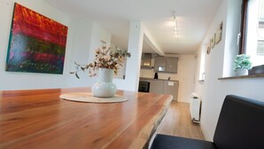 Una cocina moderna con armarios blancos, una campana extractora de acero inoxidable y un horno empotrado.
