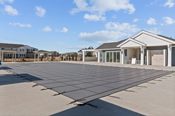 Un quartier résidentiel comprenant plusieurs maisons, un patio couvert et un grand espace ouvert équipé de panneaux solaires.
