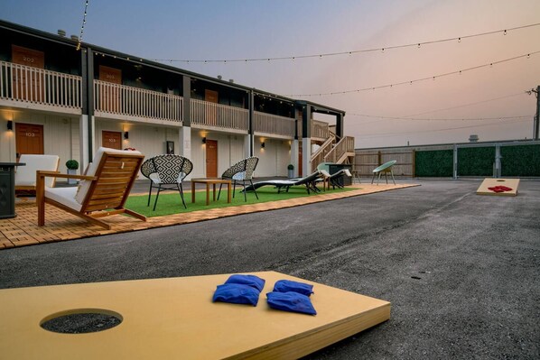 A hotel with outdoor seating and a pool area.