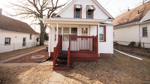 A single-story house with a front porch, a set of stairs leading to the entrance, and a small front yard. - Spacious 5-bedroom house with Wi-Fi and washer/dryer in convenient South Omaha (Omaha)