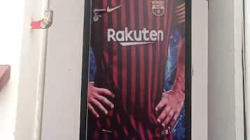 A door with a poster of a football player in a red and black striped jersey, the word "Rakuten" on it.
