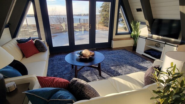 A cozy room with a large window, a sofa, a coffee table, and a TV.