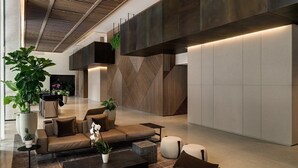 En moderne lobby med sofa, sofabord og potteplanter.