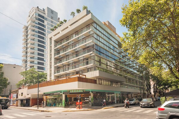 A multi-story hotel with a modern design, featuring a ground-level restaurant and a visible balcony on the upper floors. - Modern Studio in heart Palermo T309 (Buenos Aires)