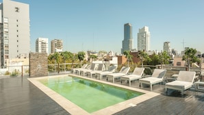 A rooftop pool area with lounge chairs, a swimming pool, and a cityscape view. - Modern Premium Studio T310 (Buenos Aires)