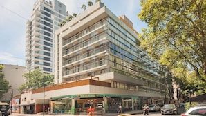 A multi-story hotel with a modern design, featuring a ground-level restaurant and a visible balcony on the upper floors. - Modern Premium Studio T310 (Buenos Aires)