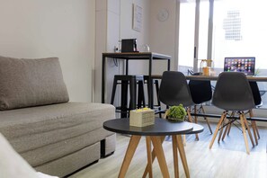 Apartament clàssic, diversos llits, balcó, vistes a la ciutat | Sala d'estar | Televisor intel·ligent de 50 polzades amb canals per cable 