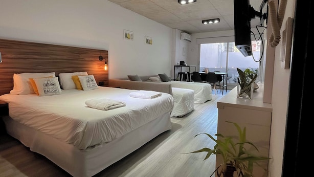 A hotel room with a large bed, a sofa, a desk, and a dining table. - Maison Thames by Argenhost (Buenos Aires)