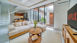 A modern living room with a sofa, coffee table, and a flat-screen TV. - Cozy 3bedroom villa Bliss, Close to Canggu,
King bed,Tranquil! (Bali)