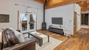 Un salon spacieux avec une cheminée, un canapé, une table basse et un téléviseur.