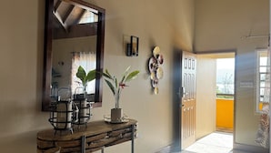Een hal met een houten console tafel, een spiegel en decoratieve wanddecoraties.
